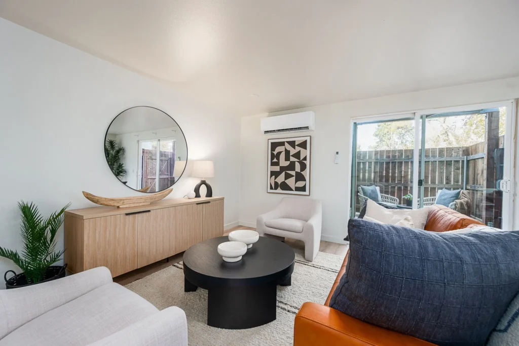 Modern staged apartment living room in Bend, Oregon featuring updated finishes, natural light, contemporary furnishings, and private outdoor patio access.