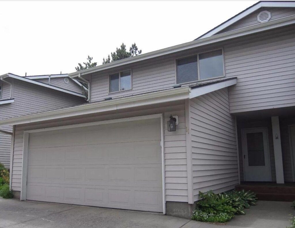 Original exterior listing photo of a single-family rental at 1801 NE Purcell Blvd in Bend, Oregon, used by the previous property manager during 50 days of vacancy. Overcast lighting, tight framing, and lower image quality reduced listing effectiveness.